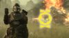 Helldiver doing fist emote to camera next to Medal icon in front of another player using a flamethrower against a charger in Helldivers 2